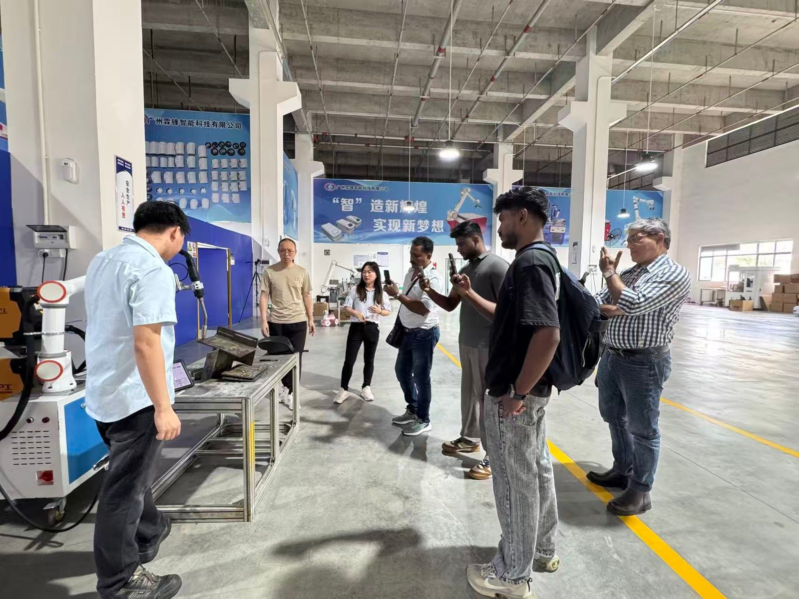 Visiting customers watching a collaborative robot demonstration at the LINFENG factory