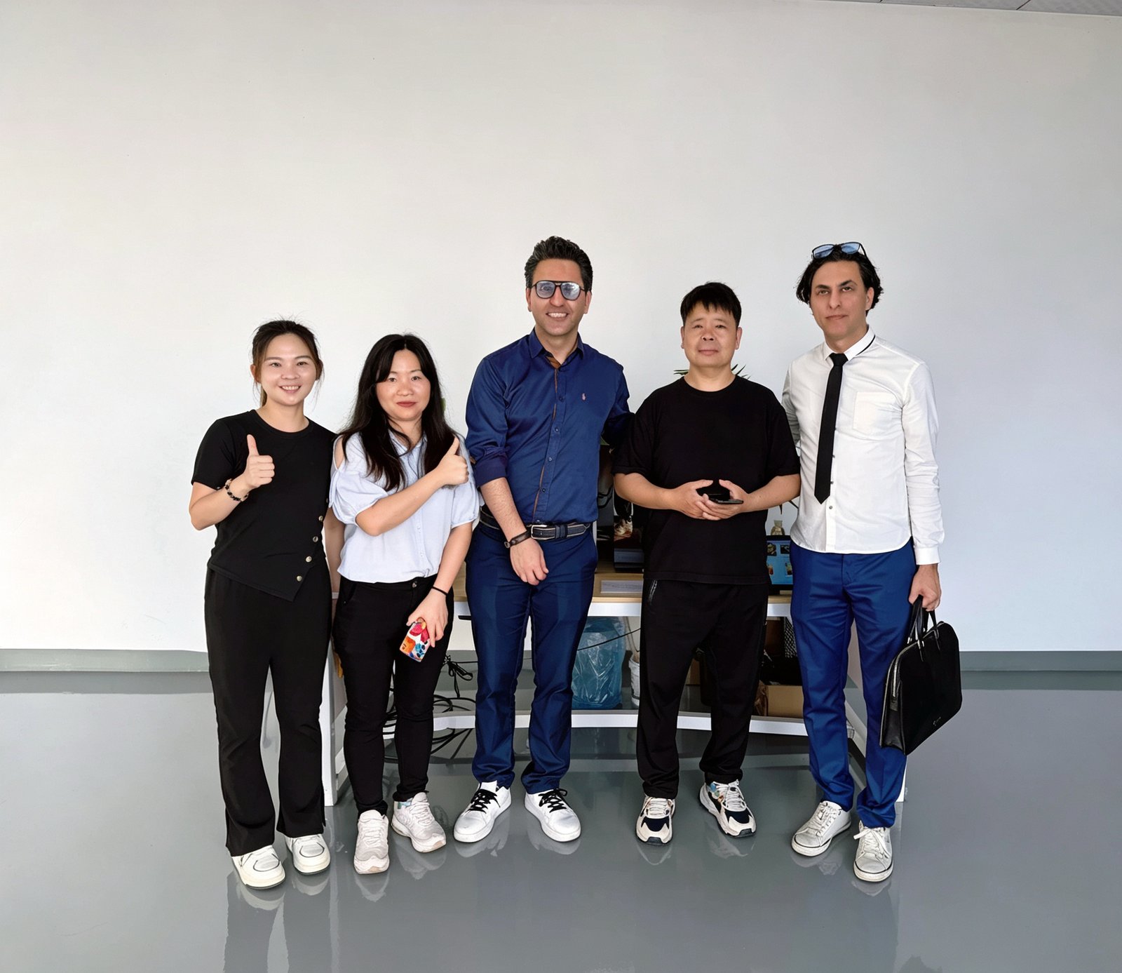 Five people from the LINFENG team and a visiting customer group posing together