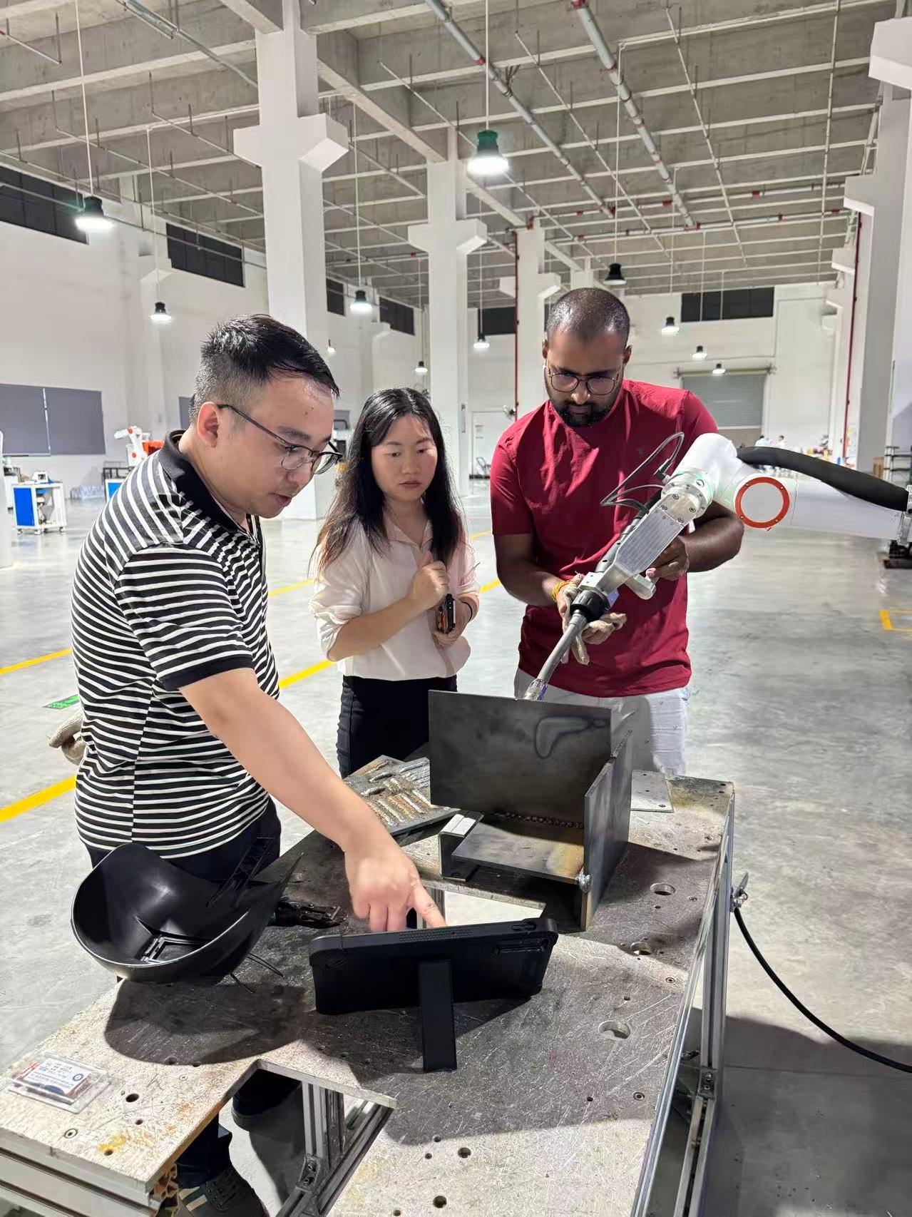 A customer reviewing a collaborative welding robot with the LINFENG team