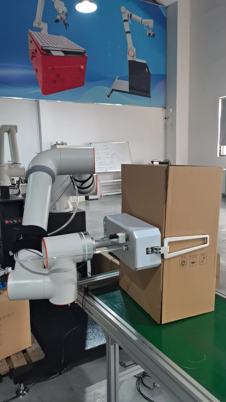 Robot tooling opening and forming a cardboard carton on a packaging workcell