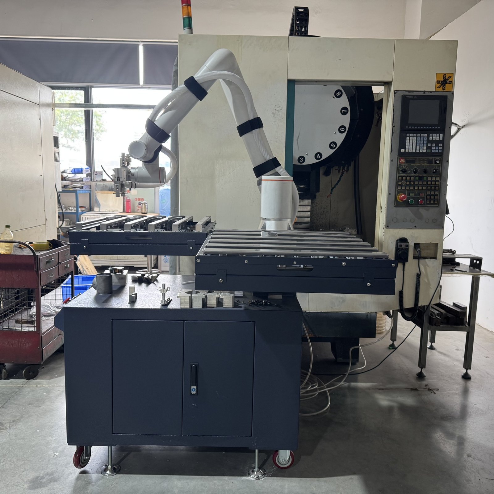 LINFENG six-axis machine tending robot with loading tables beside a machining centre