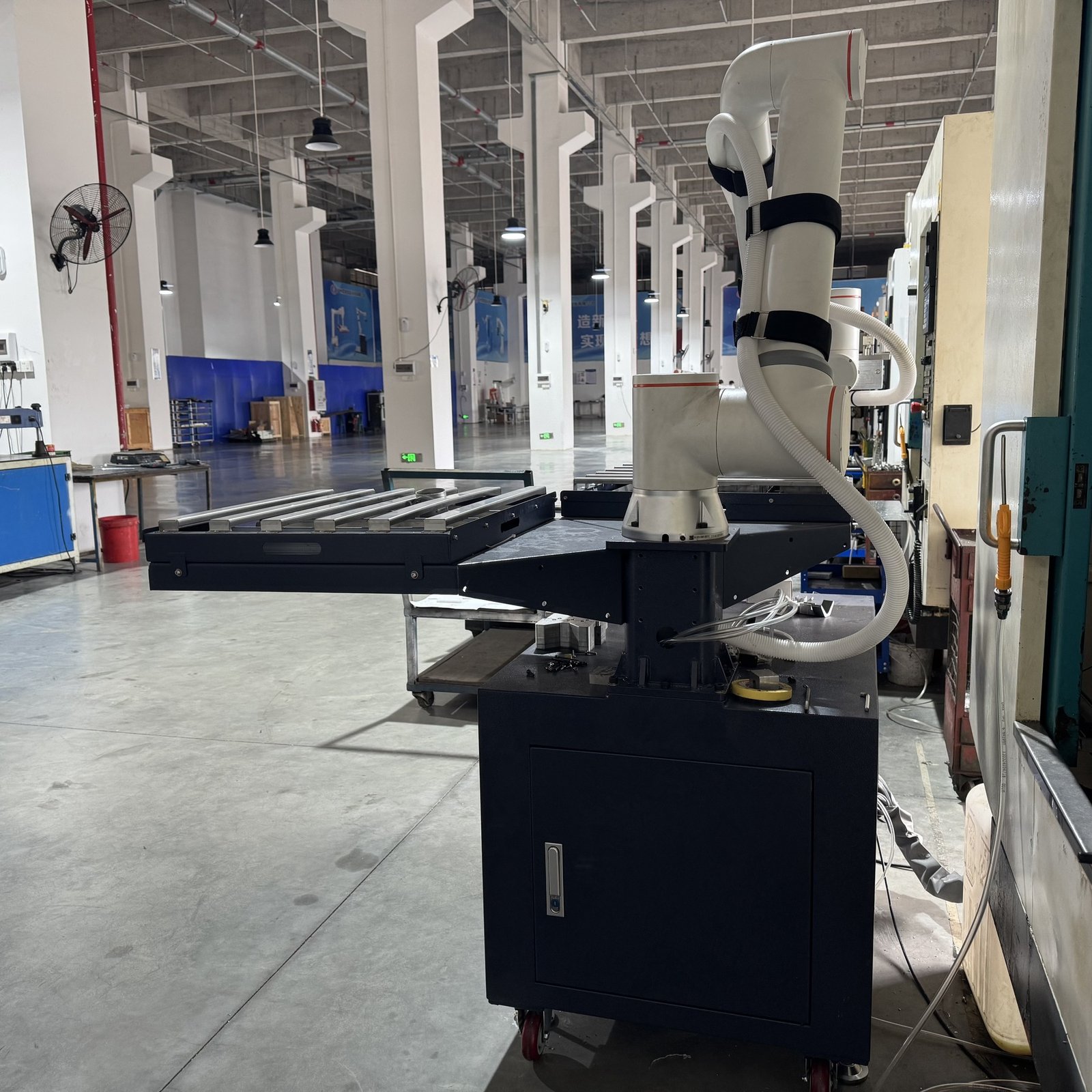 Rear view of the six-axis machine tending robot and material tables